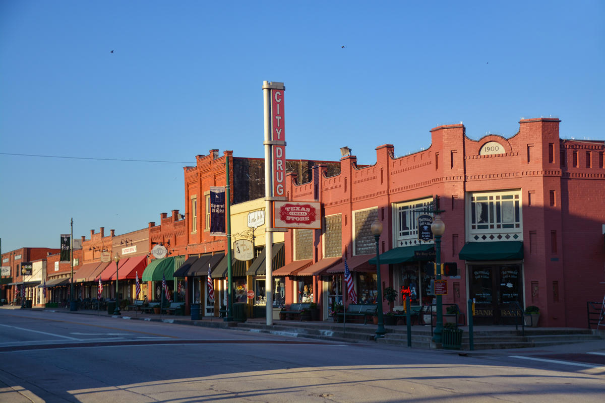 Historic Main Street in Grapevine, Texas with local shops and red brick buildings.